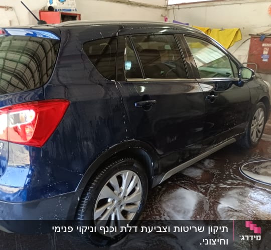 מכונית כחולה נשטפת במים וסבון במוסך